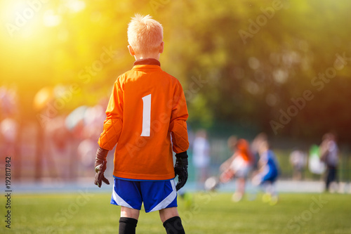 Young Soccer Goalie Goalkeeper. Young Boy Soccer Goalie. Soccer Game on Sunny Summer Day. Sport activities for children.. Football Match in the Background. Youth Sport Wallpaper. © matimix