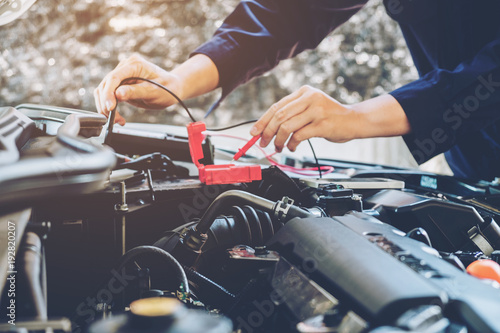 Hands of car mechanic working in auto repair service.