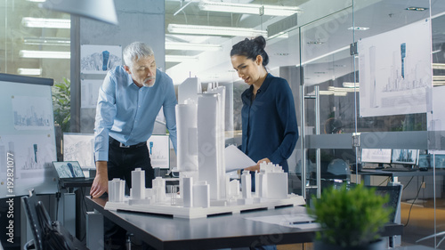 In the Architectural Bureau Two Engineers Work on a Model of a City District. Urban Planners Work on a Functional Building Model.