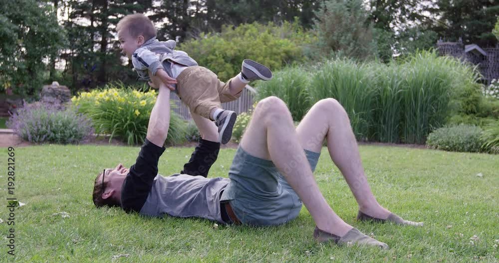 Young father holding son in arms above head - slow motion Young father holding son in arms above head - slow motion