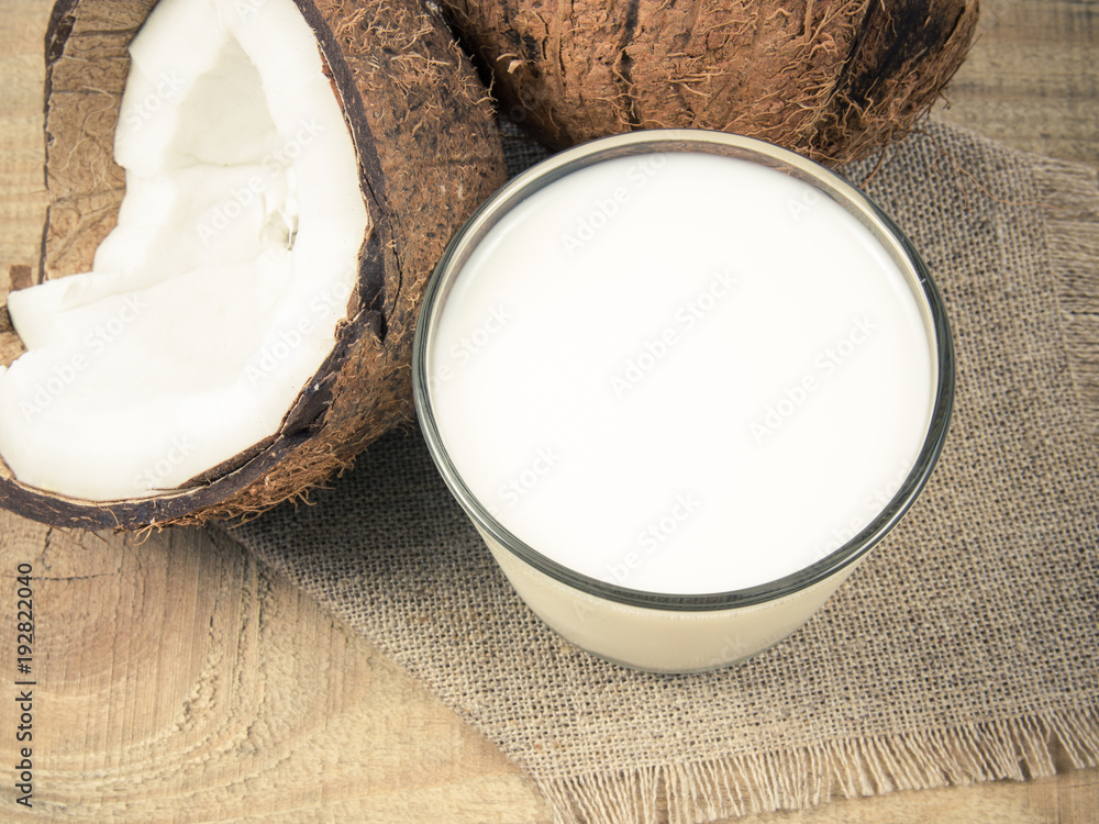 Coconut with coconut milk on wooden background. Coconut with coconut milk on wooden background.