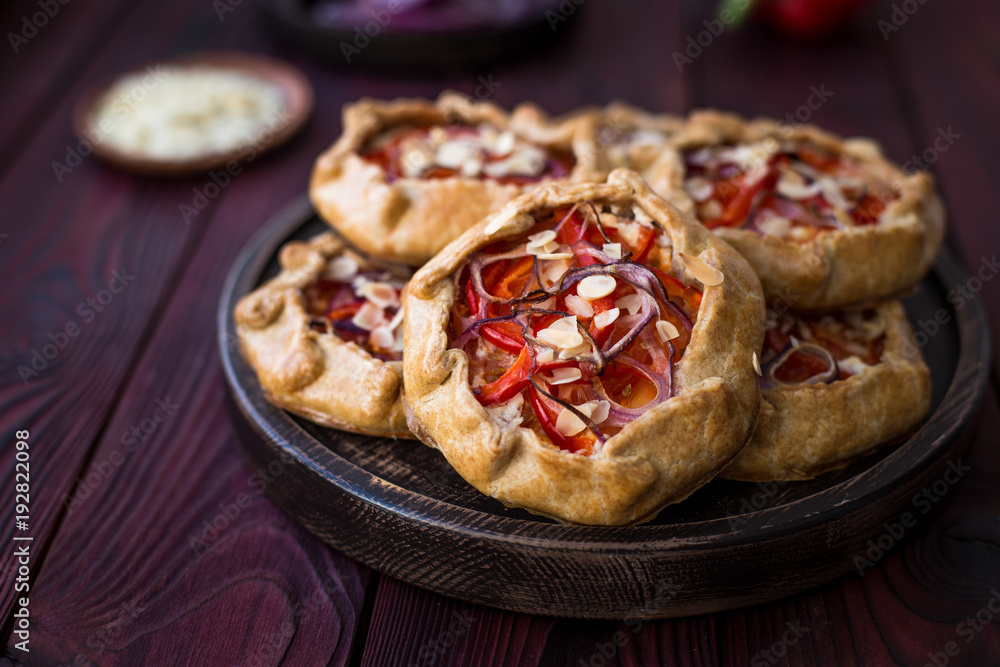Mini pizza, vegetable galette with cream cheese, red onion, tomatoes, sweet pepper and almonds