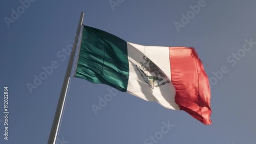 Front lit large Mexican flag waving in the wind. photo