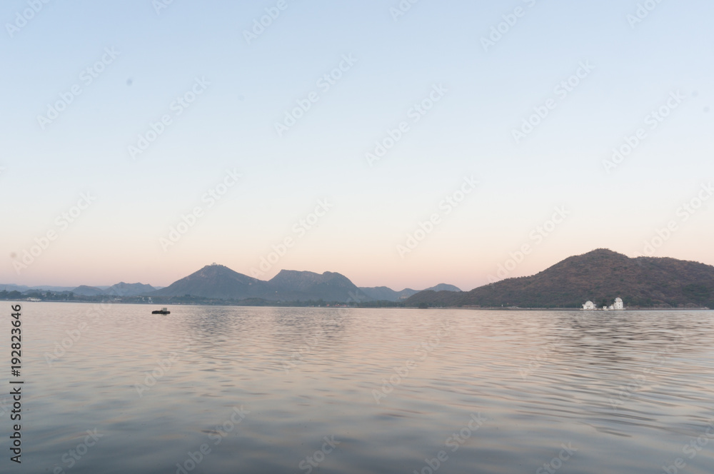Serene dawn shot of Fateh sagar lake udiapur india. This famous tourist destination of India invites locals and travellers alike to enjoy the blue waters, surrounding hills and great lakeside food
