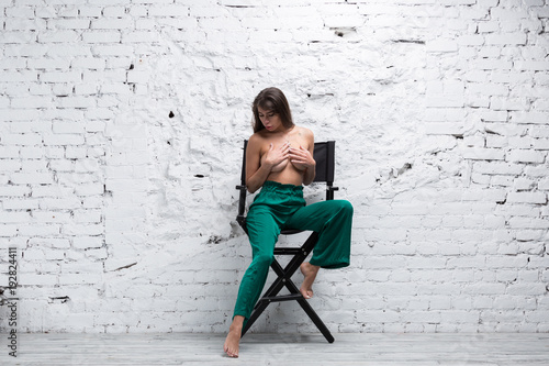 Topless brunette woman sitting on a directors chair photo
