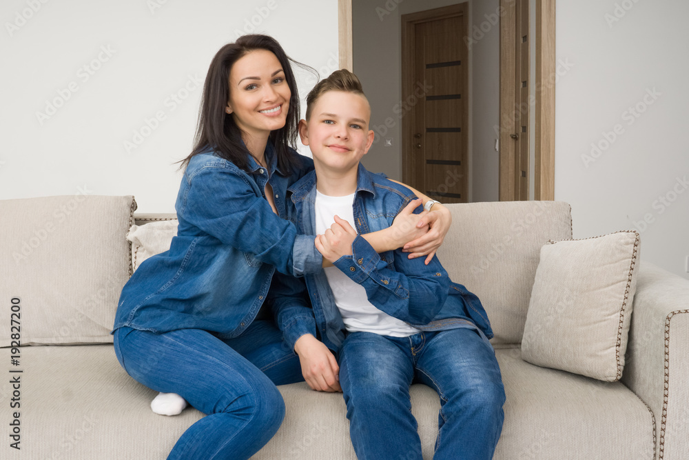 Portrait of mother and her son on sofa at home