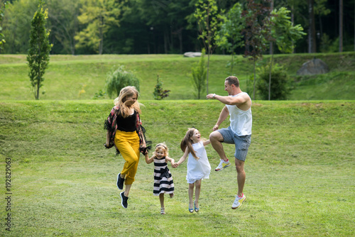 Children and parents jump on green grass