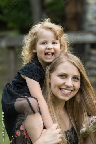 Daughter sit on mother shoulders