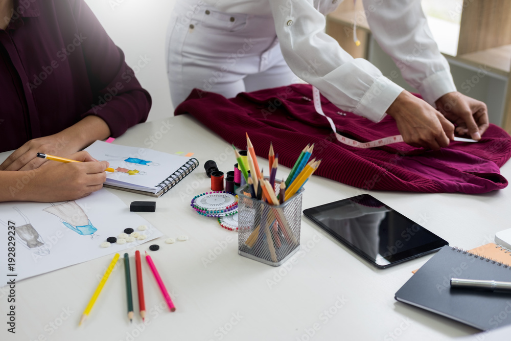 Εκτύπωση καμβά two young women working as fashion designers and drawing sketches and gets fabric advice at a custom tailor