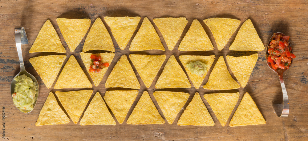 Fototapeta premium Nacho chips arranged on wooden surface