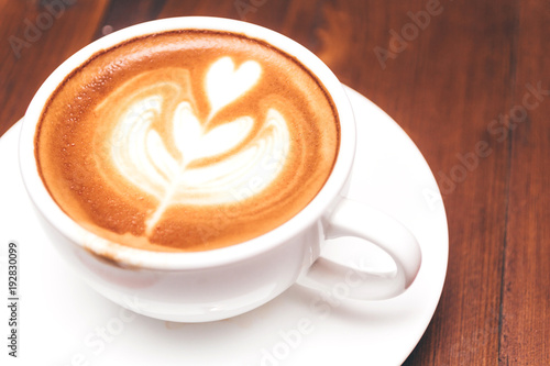 Coffee latte art on wooden table in coffee shop