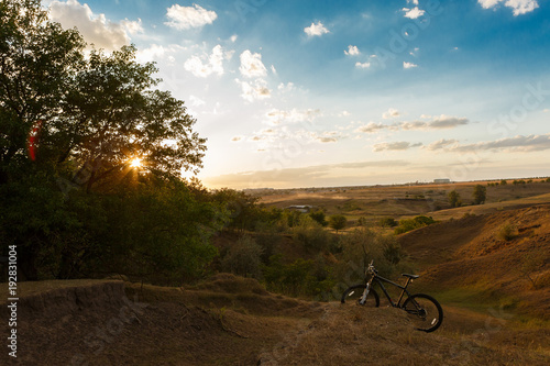 mountain bike in the background of a beautiful sunset,  on the edge of the forest