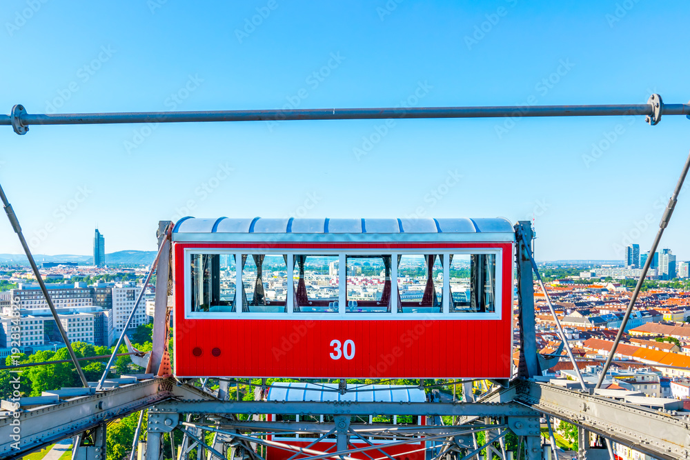 Fototapeta premium Wiener Riesenrad - Pojedynczy czerwony wagon z widokiem na Wiedeń