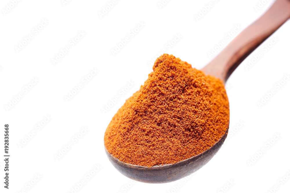 Wooden spoon full of paprica isolated on white background, close-up, top view, shallow depth of field Wooden spoon full of paprica isolated on white background, close-up, top view, shallow depth of field