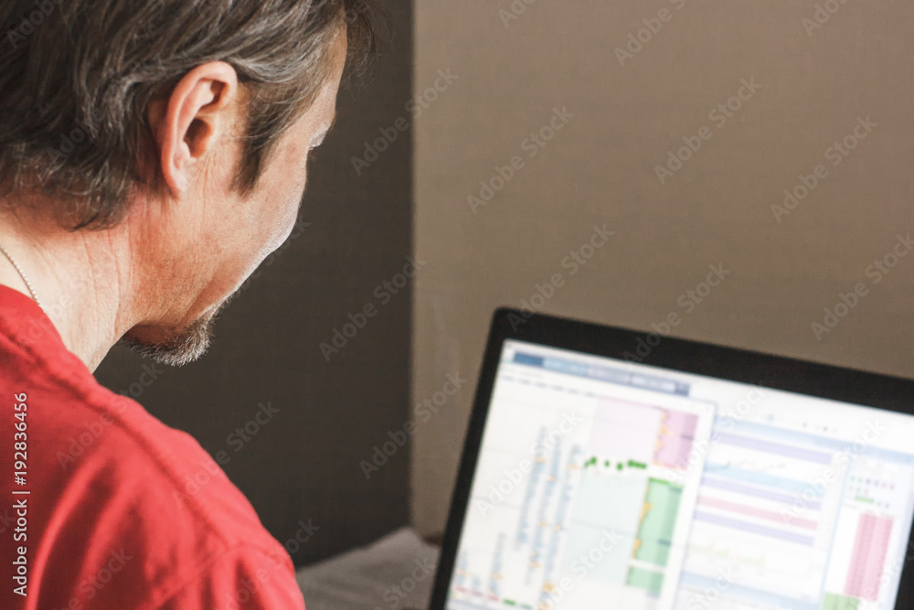 A man sitting at a computer and working on the stock exchange A man sitting at a computer and working on the stock exchange