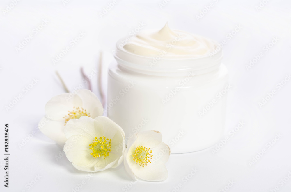 Cute flowers and a jar of natural body cream isolated on white background Cute flowers and a jar of natural body cream isolated on white background