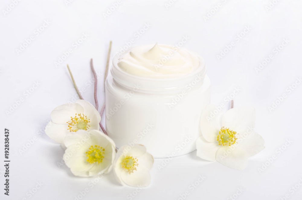Cute flowers and a jar of natural body cream isolated on white background