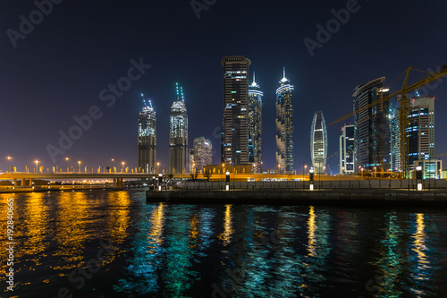 Panoramic view of Dubai Business bay at night, reflection of the lights in Dubai Creek. Dubai, UAE