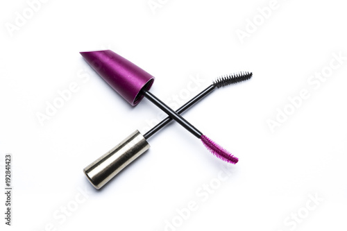 Pink and black mascara brushes for eyelashes crossing like a scissors on white background.