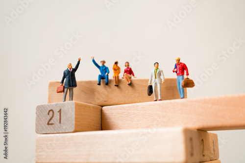 Miniature people, business team standing on wooden block using as business concept