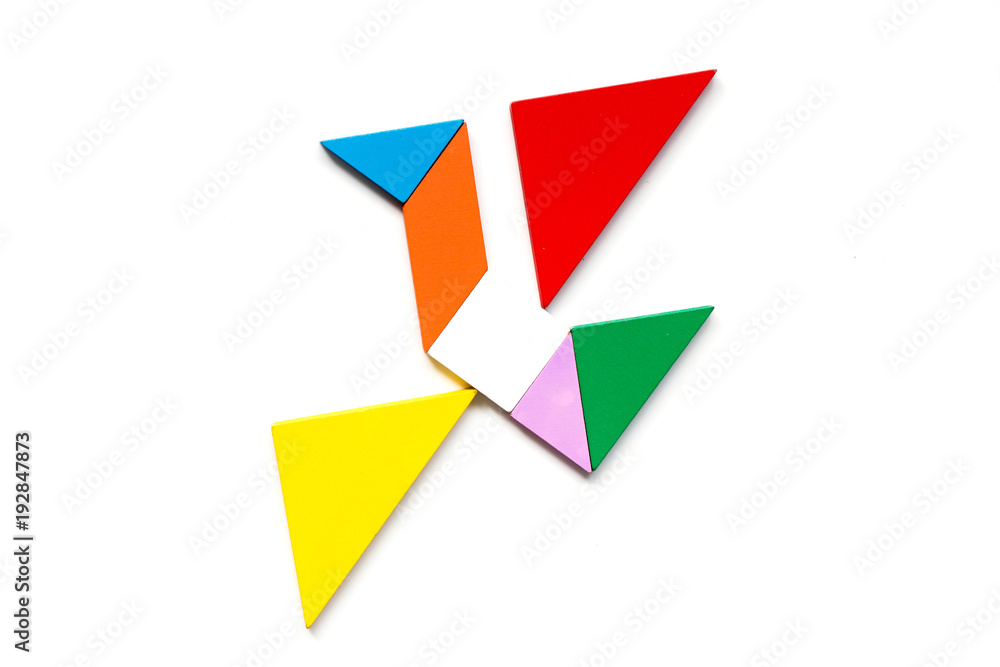 Color wood tangram puzzle in flying bird shape on white background Color wood tangram puzzle in flying bird shape on white background