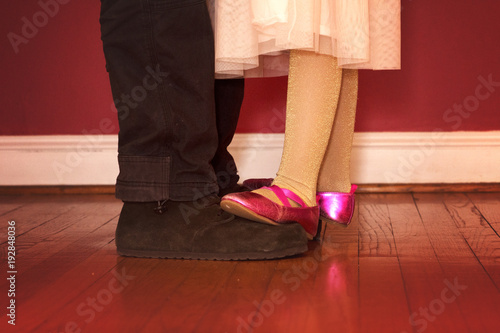 daughter dancing on father's feet in formal wear