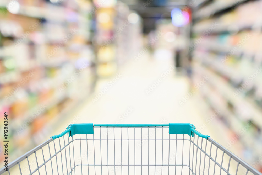 blur supermarket aisle with empty green shopping cart background