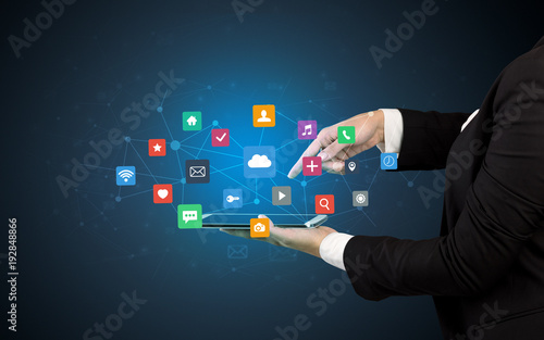 Hand holding tablet and application icons above