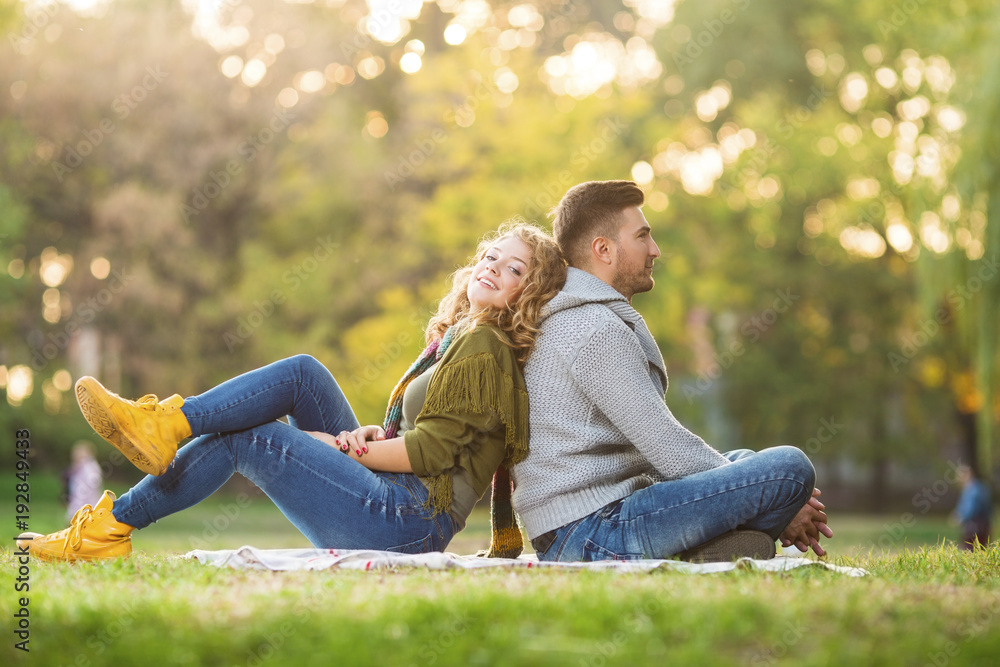 Fototapeta premium Young couple in park posing in front of a camera