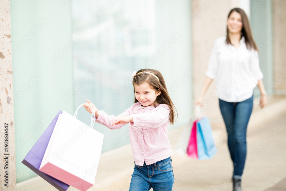 Cute little girl enjoying shopping with her mother at back Cute little girl enjoying shopping with her mother at back