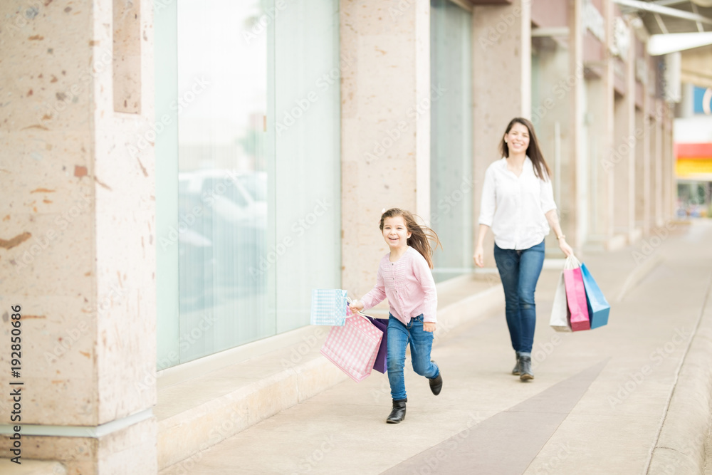 Mother and daughter having fun while shopping in mall Mother and daughter having fun while shopping in mall
