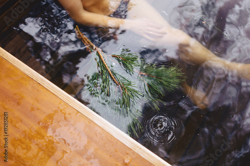 Pine branches near a hot conifer in a water of hot tube spa