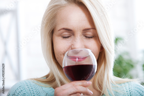 Closeup portrait of female customer drinking red wine with eyes closed.