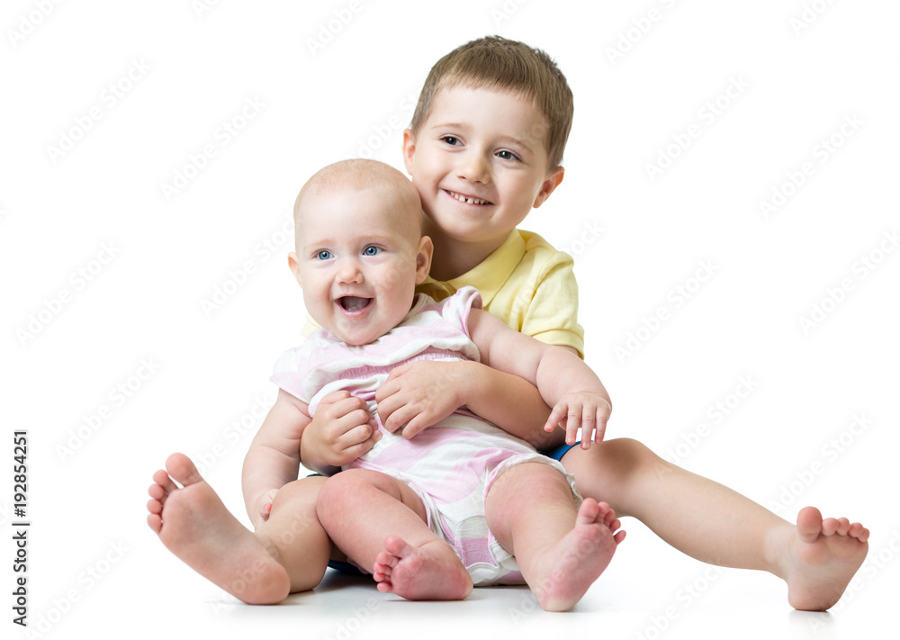 Portrait of kid brother hugging his little cute sister sitting on floor isolated on white background Portrait of kid brother hugging his little cute sister sitting on floor isolated on white background