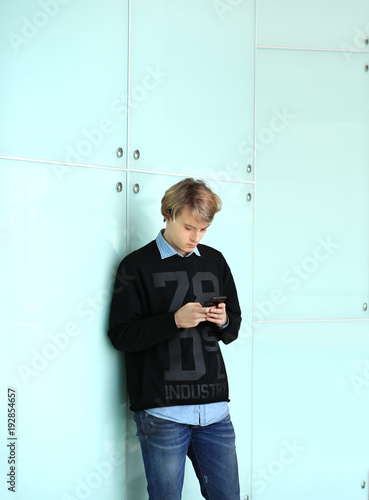 Foto Lifestyle portrait of young man using a smart phone outdoors