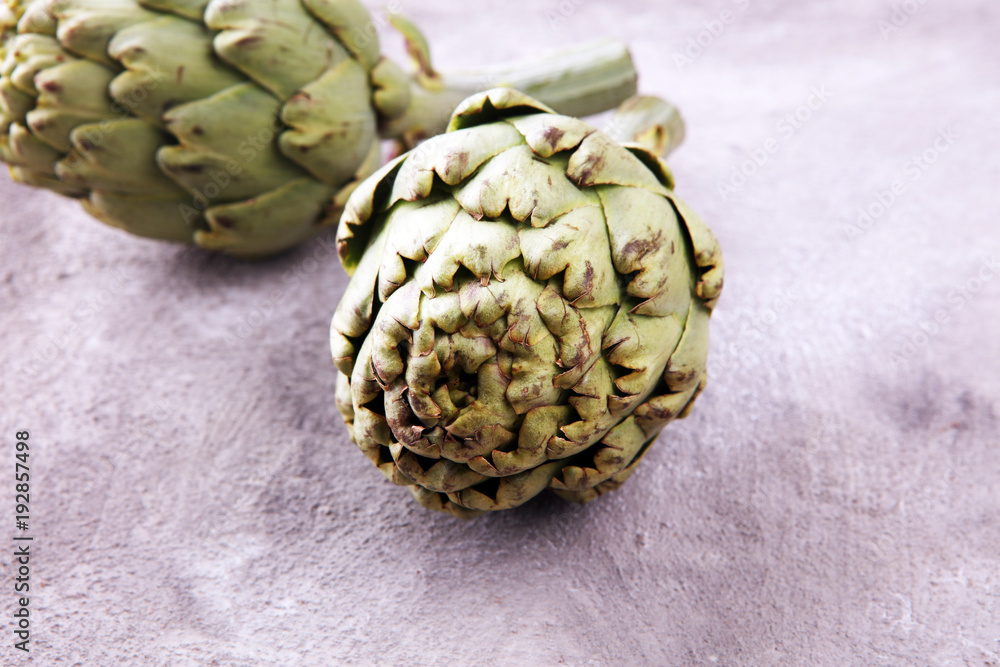 Obraz premium artichokes on grey background. fresh organic artichoke flower.