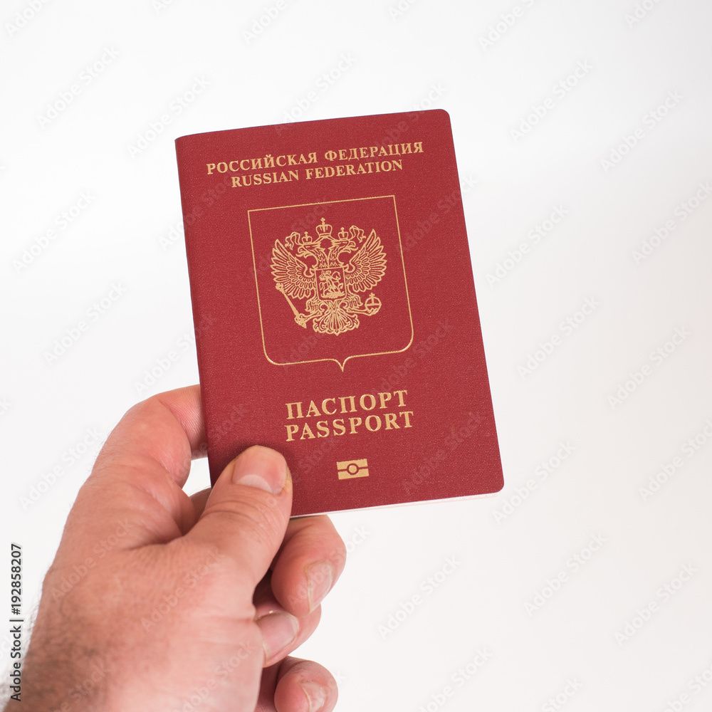 Man's Hand holding Russian international passport isolated on white background Man's Hand holding Russian international passport isolated on white background