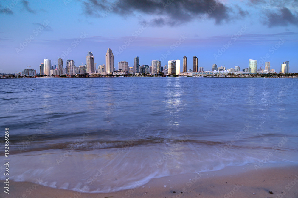 Naklejka premium The sunset over the San Diego skyline across San Diego Bay from Coronado Island.