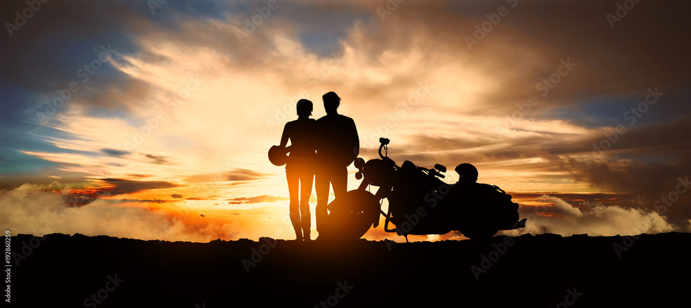 Fototapeta premium młoda zaręczona para wysiąść z motocykla, by podziwiać zachód słońca