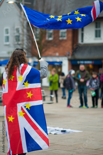 Female Brexit protestor European demonstration with UK flag and EU banner in typical English high street during protest march photo