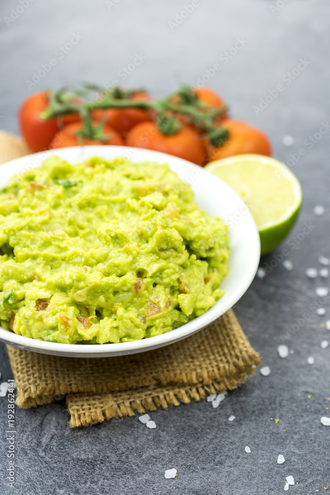 Bowl of guacamole on black wooden background. Bowl of guacamole on black wooden background.