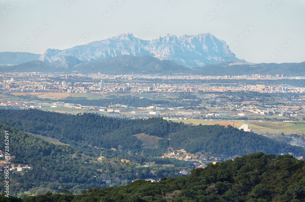 Montserrat multi-peaked mountain at background and towns in the surrounding area