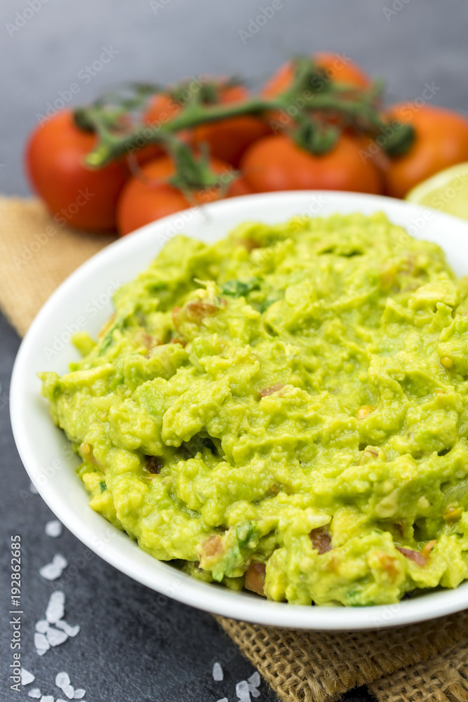 Bowl of guacamole on black wooden background. Bowl of guacamole on black wooden background.
