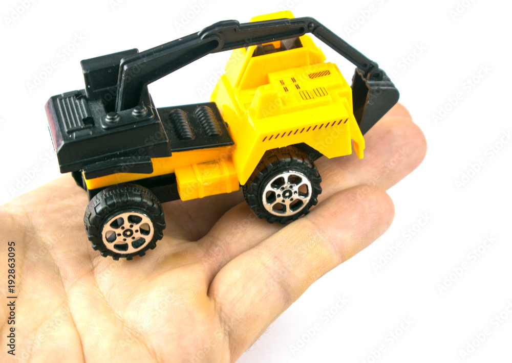 A toy excavator on a hand on a white background. Isolated.