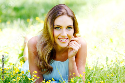 young woman in blue dress lying on grass