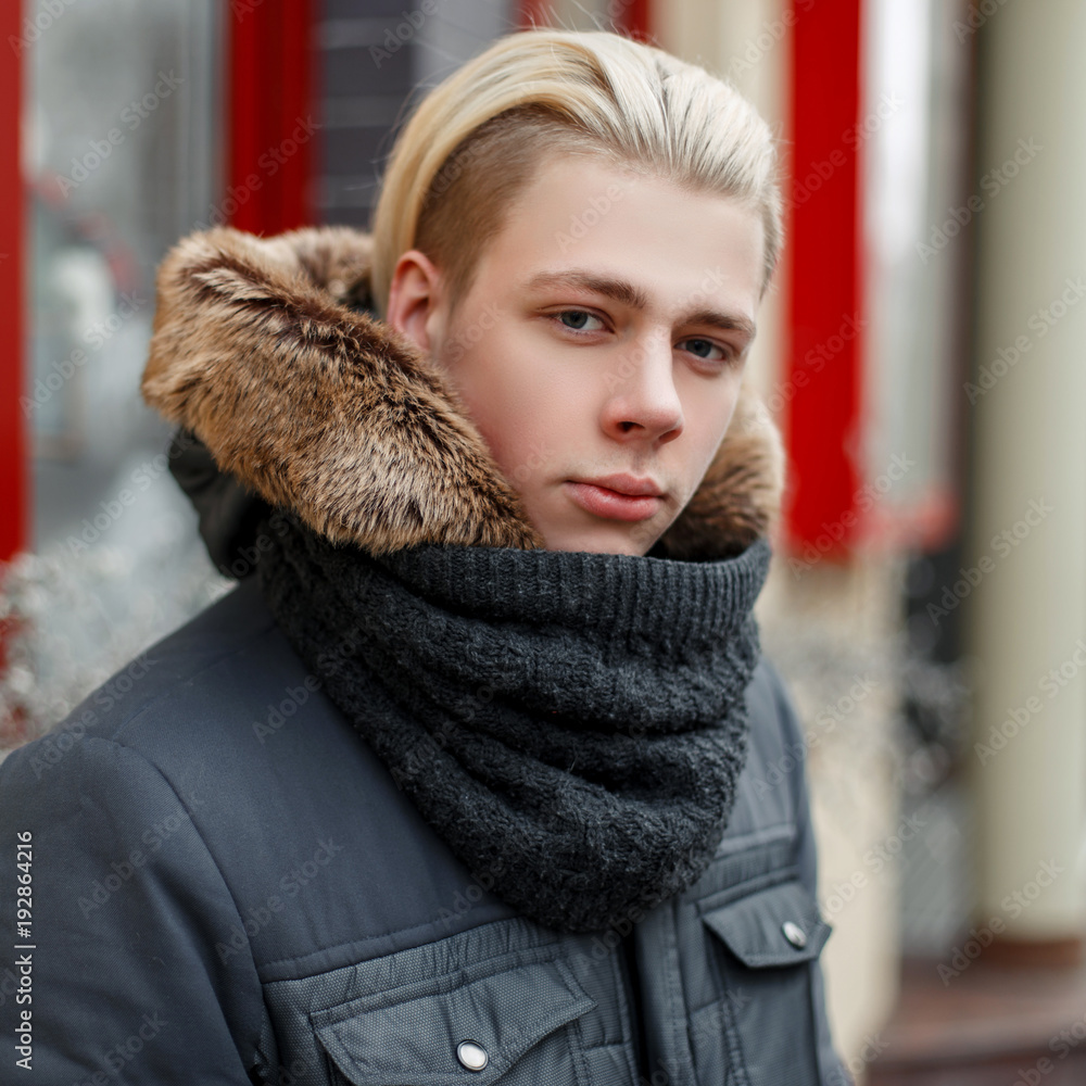 Winter portrait of a young man with a stylish hairstyle in a fashionable  winter jacket and a scarf on the street Stock Photo | Adobe Stock