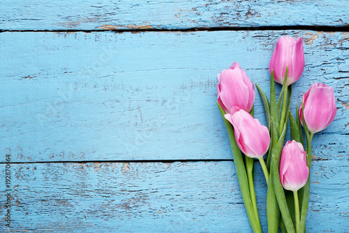 Bouquet of pink tulips on blue wooden table