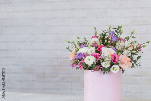 Fresh and lush bouquet of colorful flowers, on white brick background with copyspace © uv_group