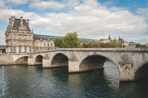 View on museum of Louvre and bridge over river Seine on bright summer day in Paris, France © finaeva_i