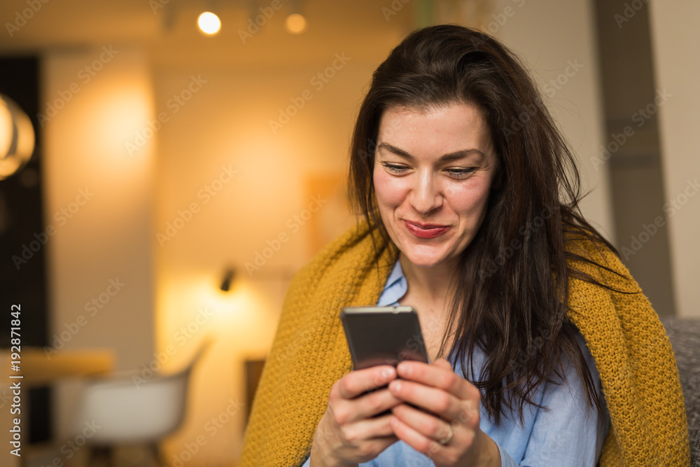 He always make me smile. Woman texting message at her home He always make me smile. Woman texting message at her home
